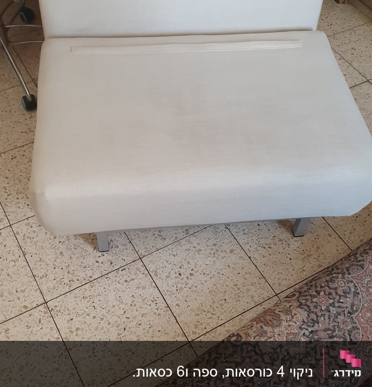 ספה בהירה על רצפת אריחים ליד שטיח מעוצב